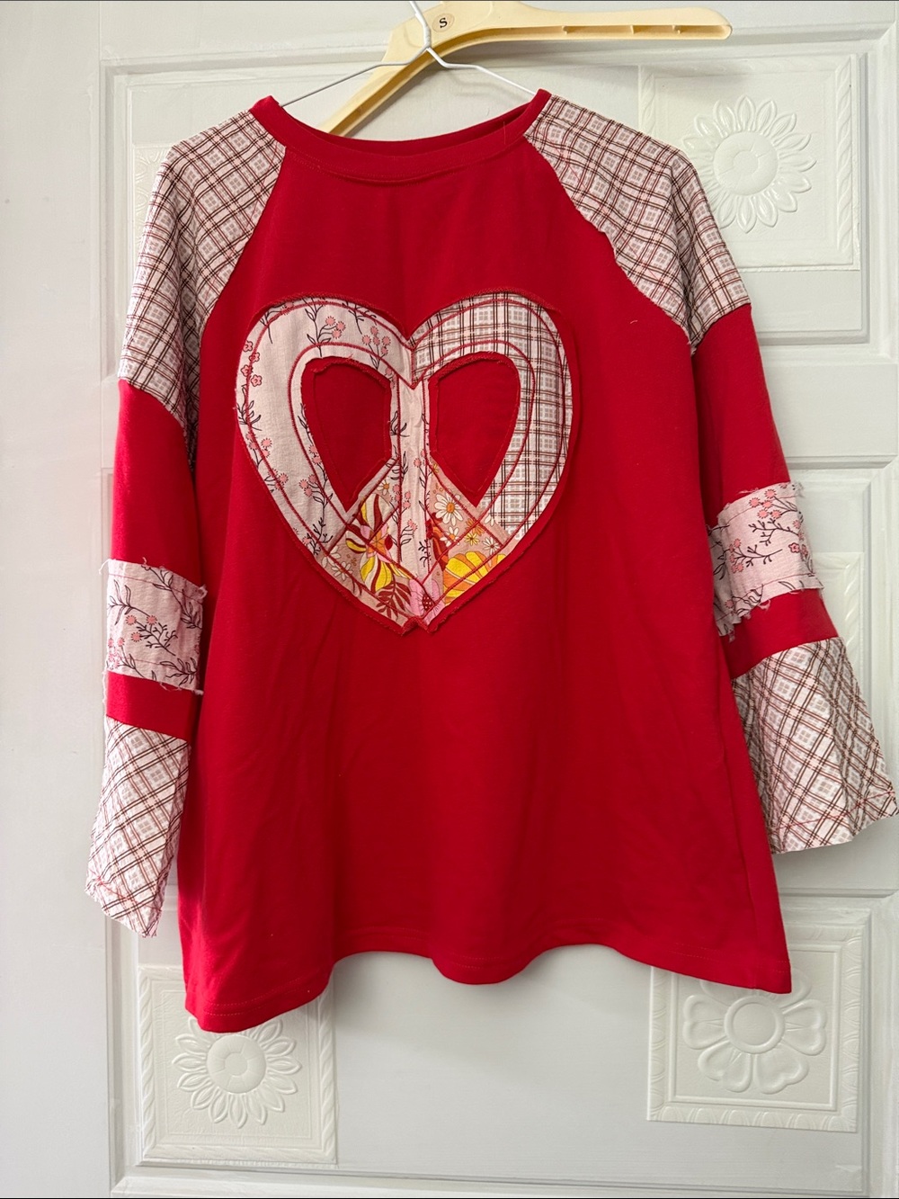 NWOT cute top with peace sign on the front, size large.